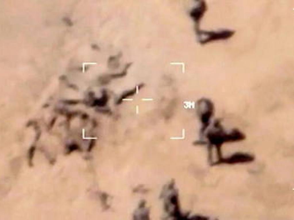 Cette image, prise par un drone Reaper de l' armee francaise, montre des mercenaires de Wagner en train d' enterrer des corps dans le sable.
