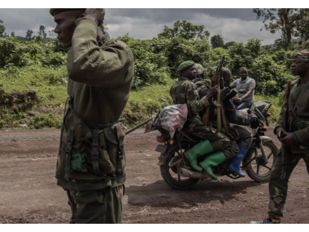 Un motocycliste transporte des soldats tandis que d’autres patrouillent dans la zone de Kibumba qui a été attaquée par des rebelles du M23 lors d’affrontements avec l’armée congolaise, près de la ville de Goma, dans l’est de la RDC, le 1er juin 2022. © Photo by Guerchom Ndebo / AFP