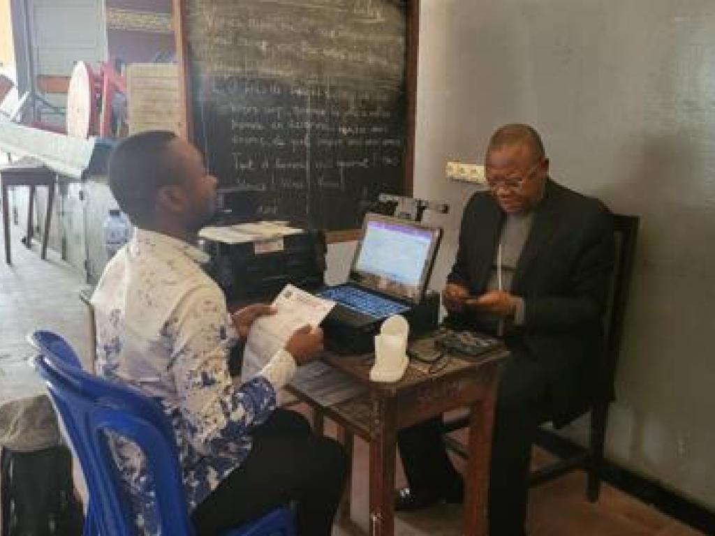 Le cardinal Fridolin Ambongo s'enregistre comme électeur au centre d'inscription du collège Saint Raphael de Kinshasa, ce mardi 27 decembre 2022. Ph/ Droits tiers
