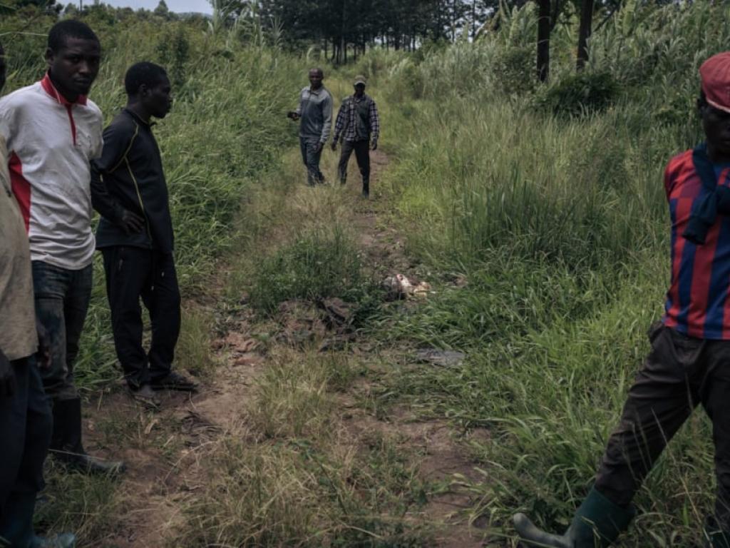 Des hommes devant un cadavre gisant sur un chemin à Kishishe, dans l’est de la République démocratique du Congo, le 5 avril 2023. © ALEXIS HUGUET / AFP