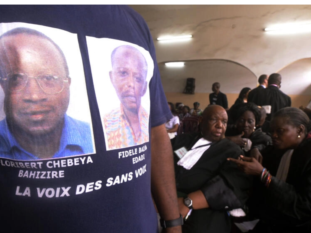 Un homme avec un t-shirt avec les portraits de Floribert Chebeya et Fidèle Bazana attend, en avril 2013, le procès d'un des principaux accusés dans l'affaire. (Photo d'illustration) AFP PHOTO / JUNIOR D. KANNAH