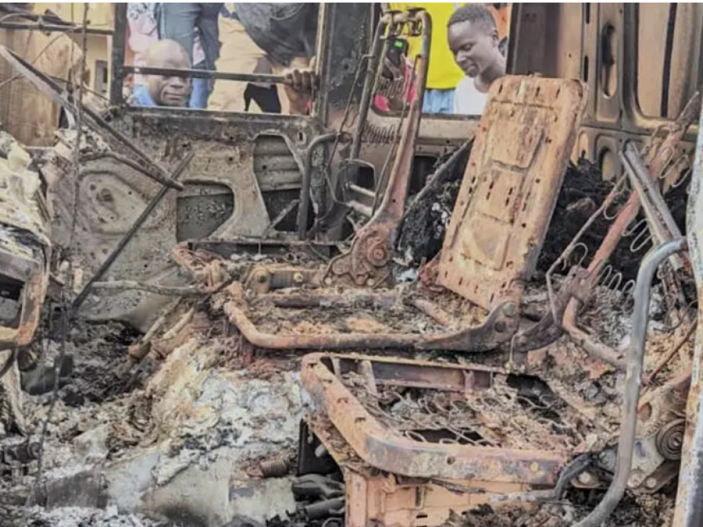 Des personnes se rassemblent autour des restes calcinés d'un véhicule incendié à la suite d'une attaque meurtrière à Komanda, dans la province d'Ituri, dans l'est du Congo, le dimanche 27 juillet 2025. AP - Olivier Okande